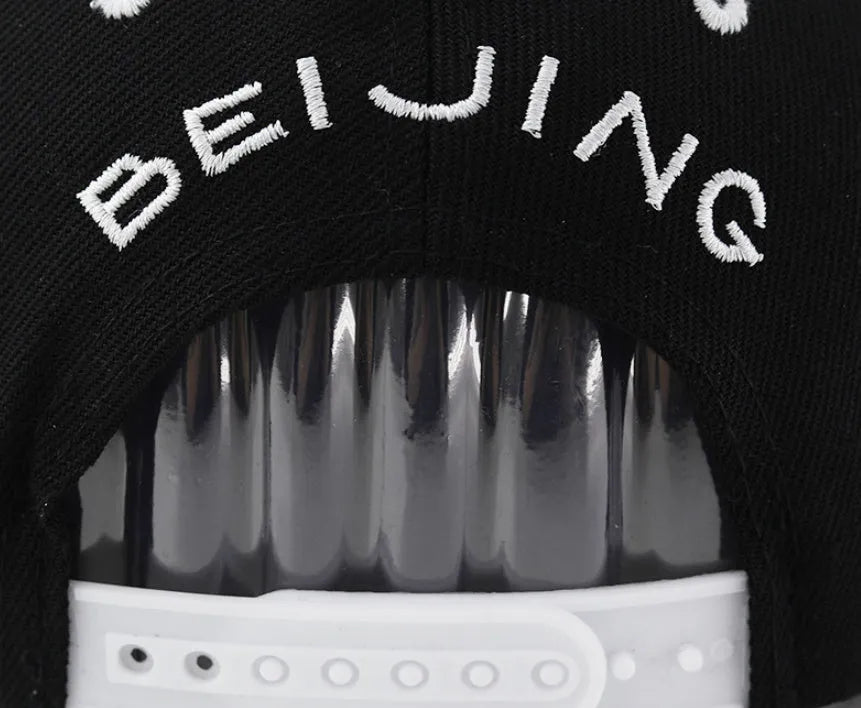Cotton baseball cap with embroidered lettering on the front, shown in black and white colours