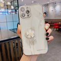 Green iPhone case with a spinning 3D white floral decoration and built-in screen protector.