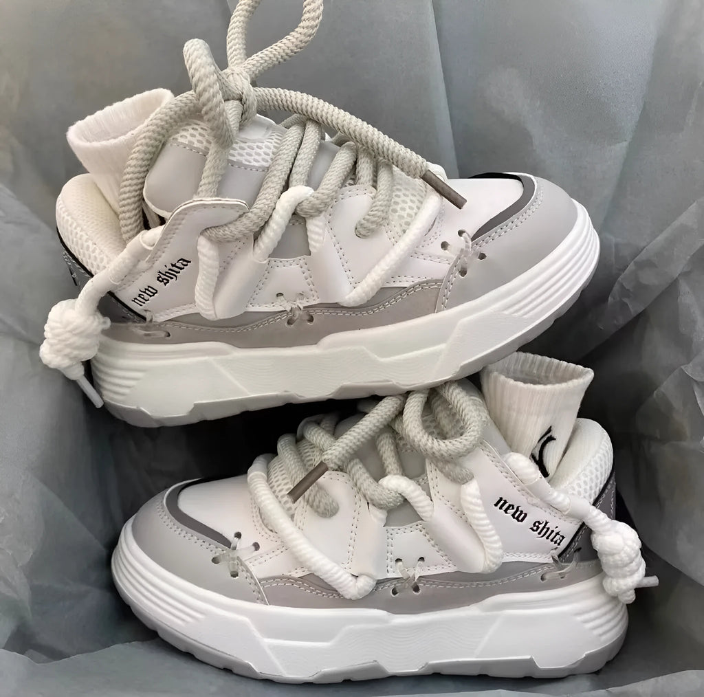 Women's grey retro clunky sneakers with a thick rubber sole and flat heel on a plain background.