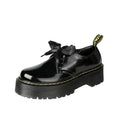 Women's black and white lace-up shoes with thick soles, ribbon details, and cross straps.