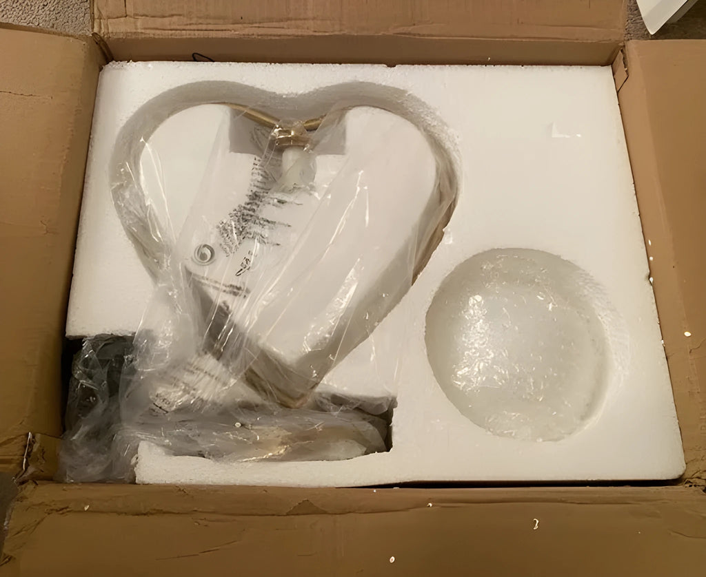 Small white heart-shaped acrylic table lamp with soft glow on a wooden surface.