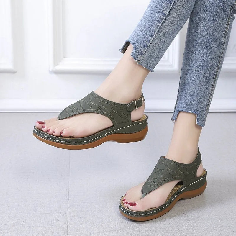 Women's black wedge heel sandals with an adjustable buckle back strap on a plain background.