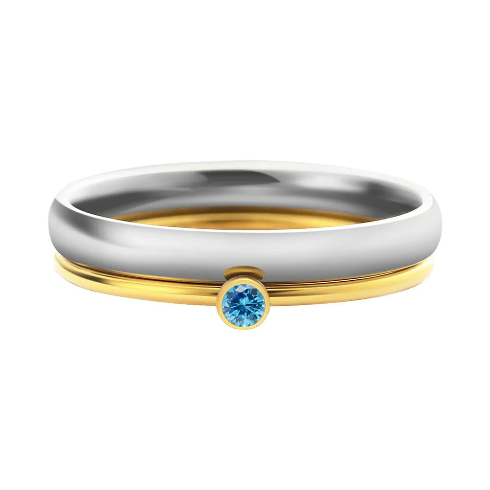 Close-up of a titanium steel ring with an engraved geometric design and a December colour birthstone.