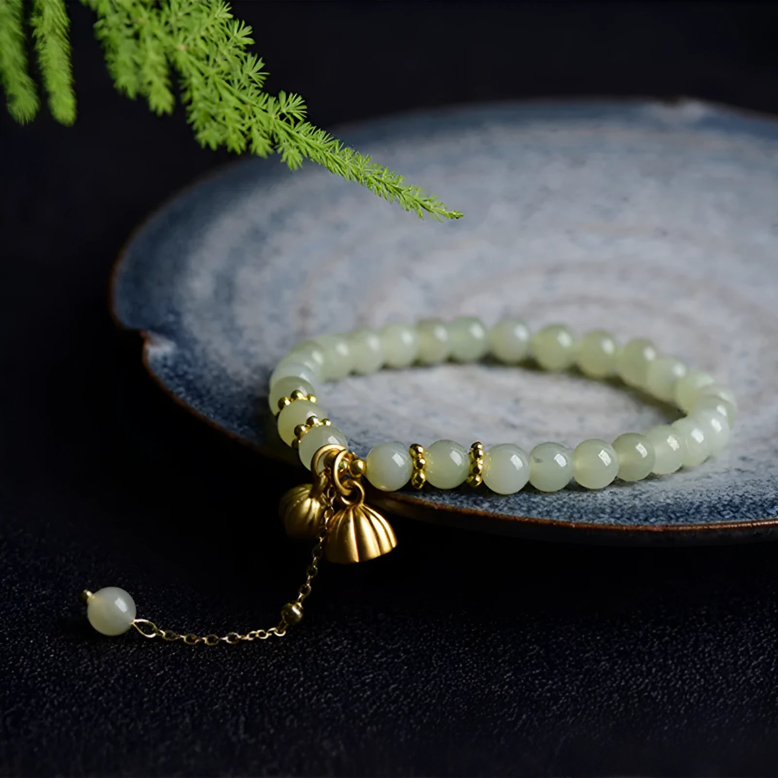 Natural Hetian jade bracelet with a carved Fu character charm on a wrist.