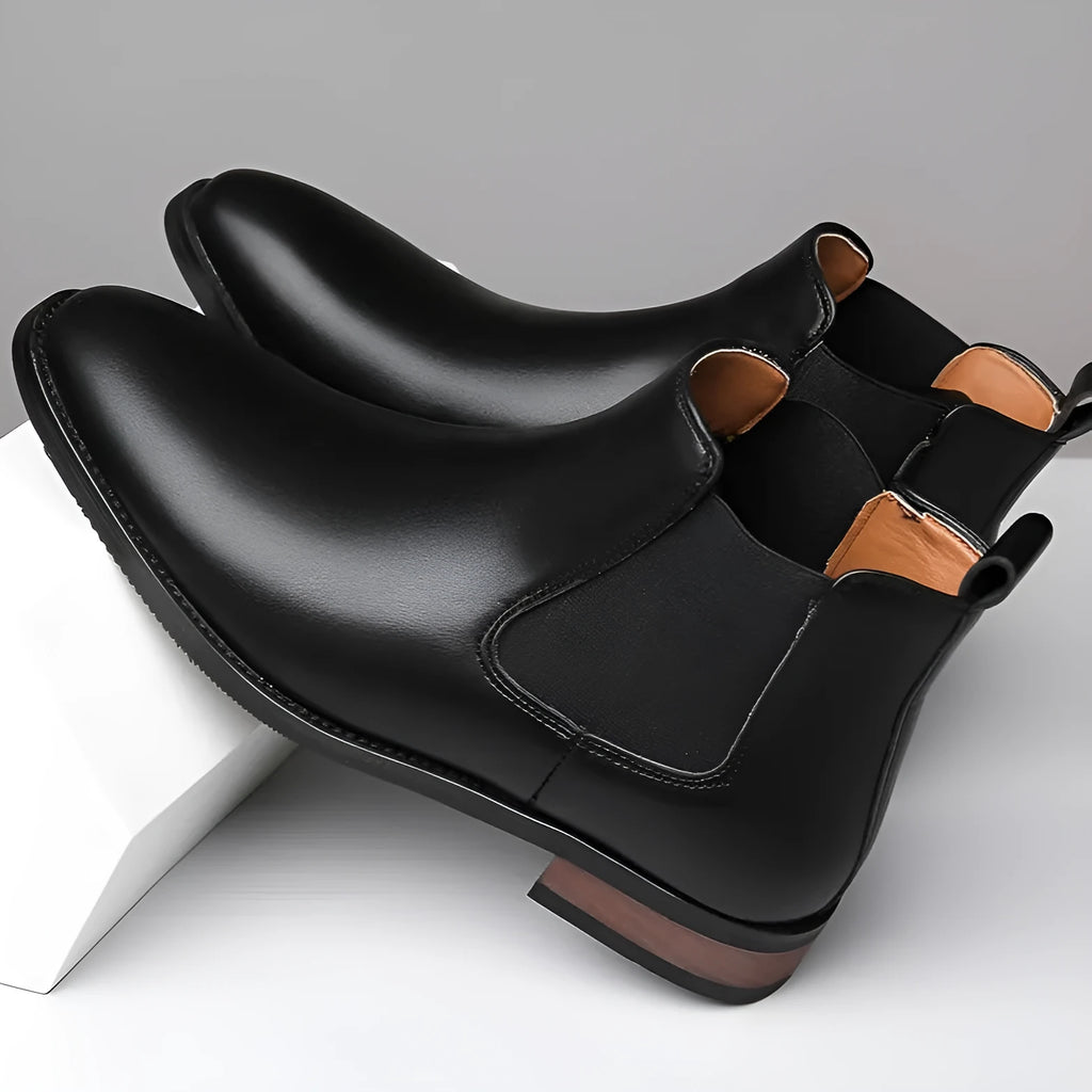 Men's black Chelsea boots with round pointed toe and visible stitching detail