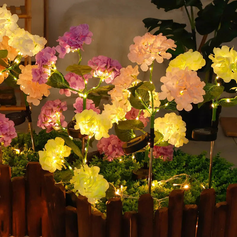Solar hydrangea garden lights with plant-shaped design and floor outlet base in outdoor setting
