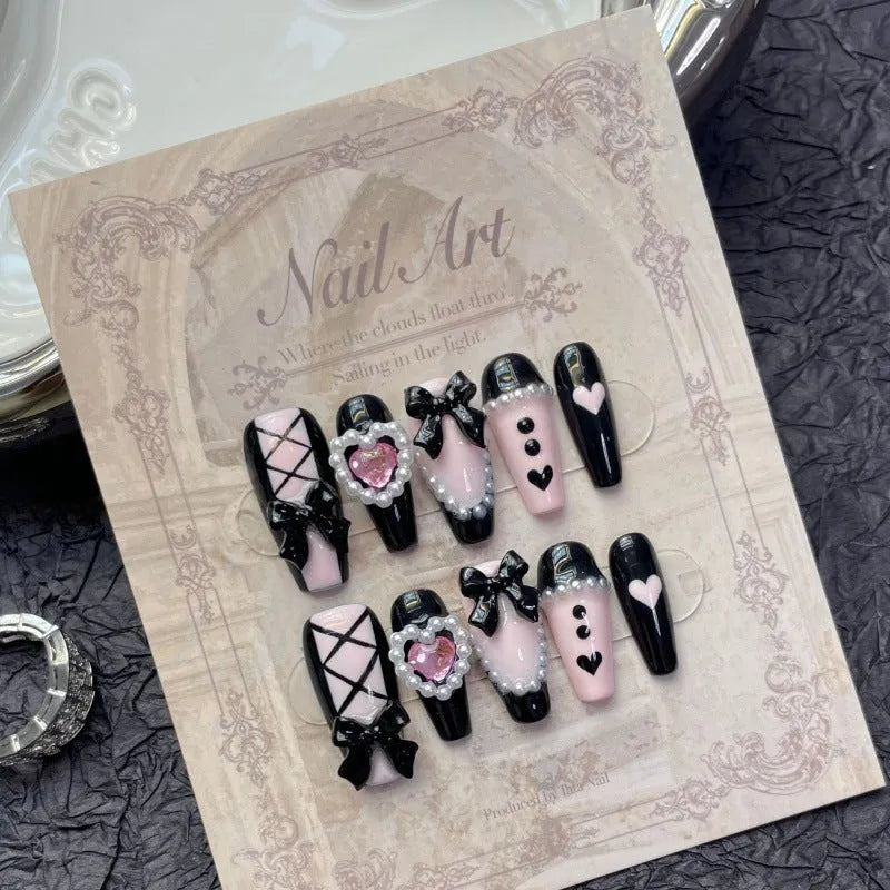 Handmade black peach heart nail art with detachable bow patterns on plastic armour suit