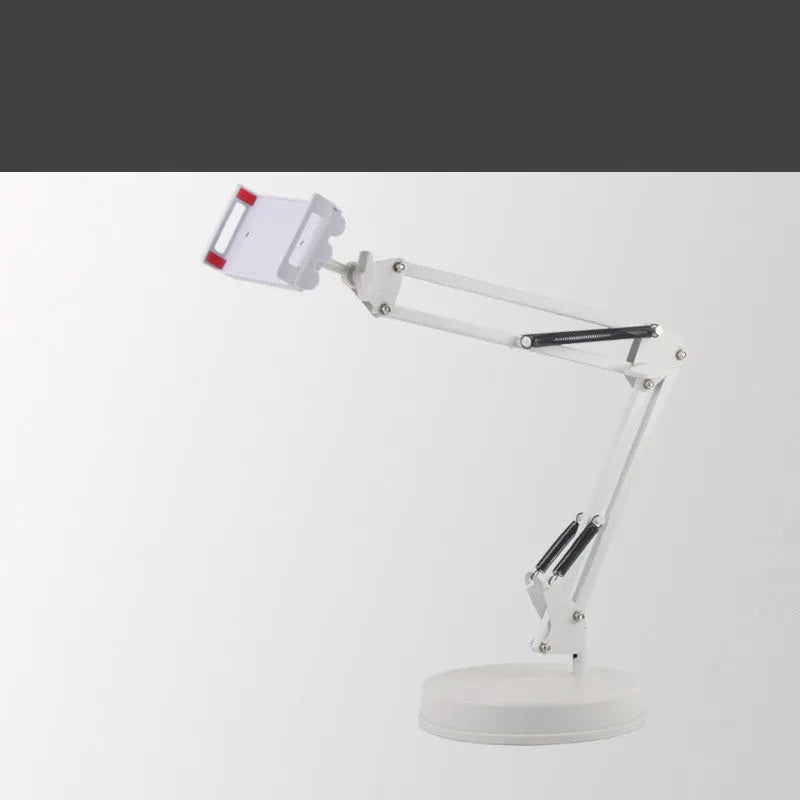 Black universal phone stand with long rotating metal arms and a heavy round base on a wooden desk.