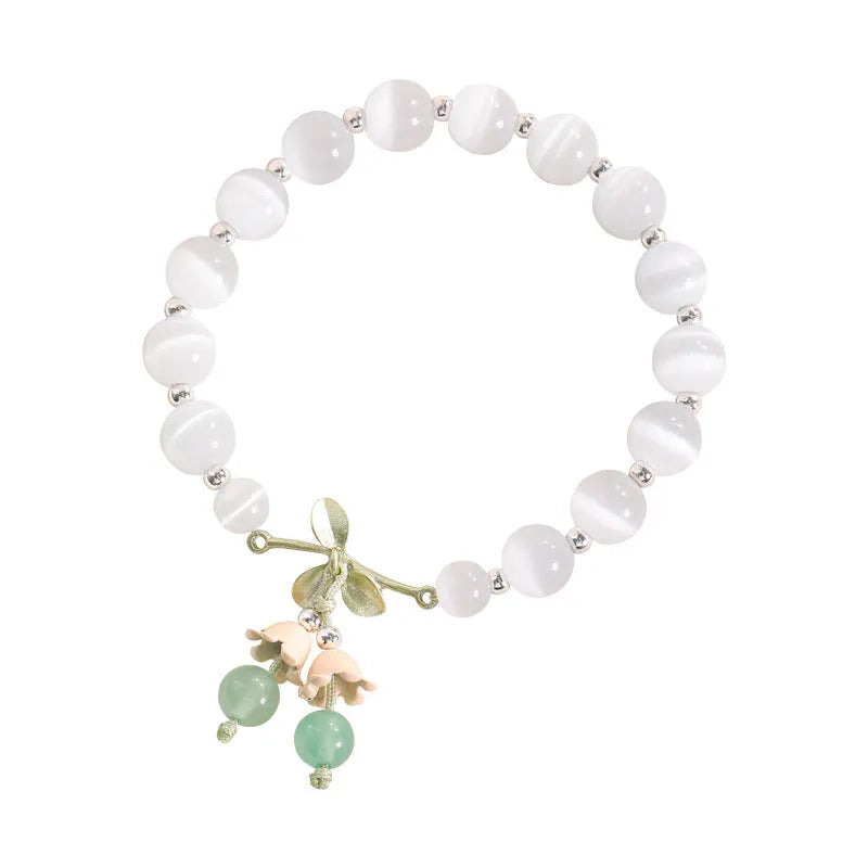 Women's opal cat's eye stone bracelet with diamond-shaped beads on wrist.